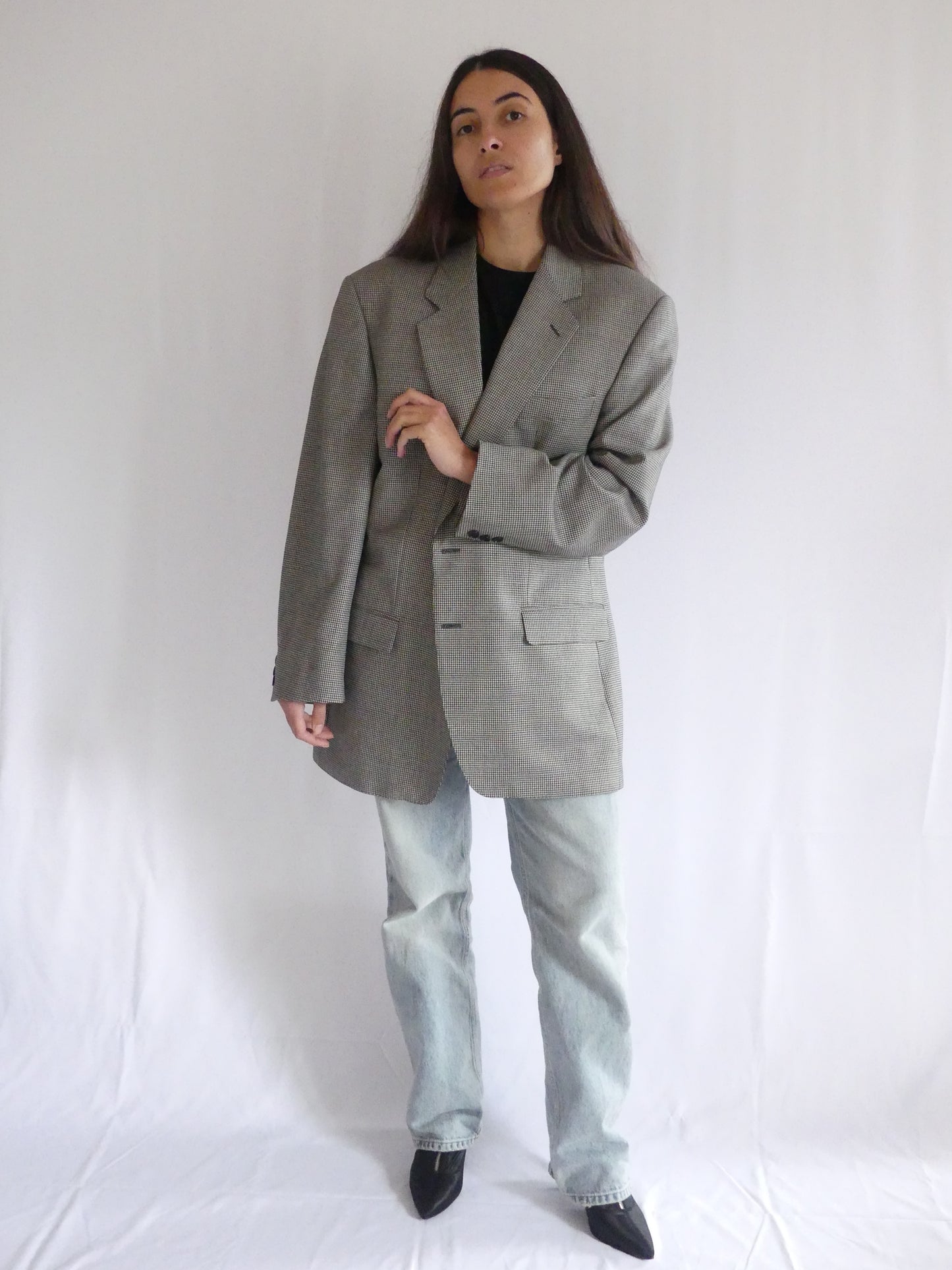 Woman wearing the Gaspard vintage blazer in black and white houndstooth, styled for a chic European look – made in France with luxurious English cloth.