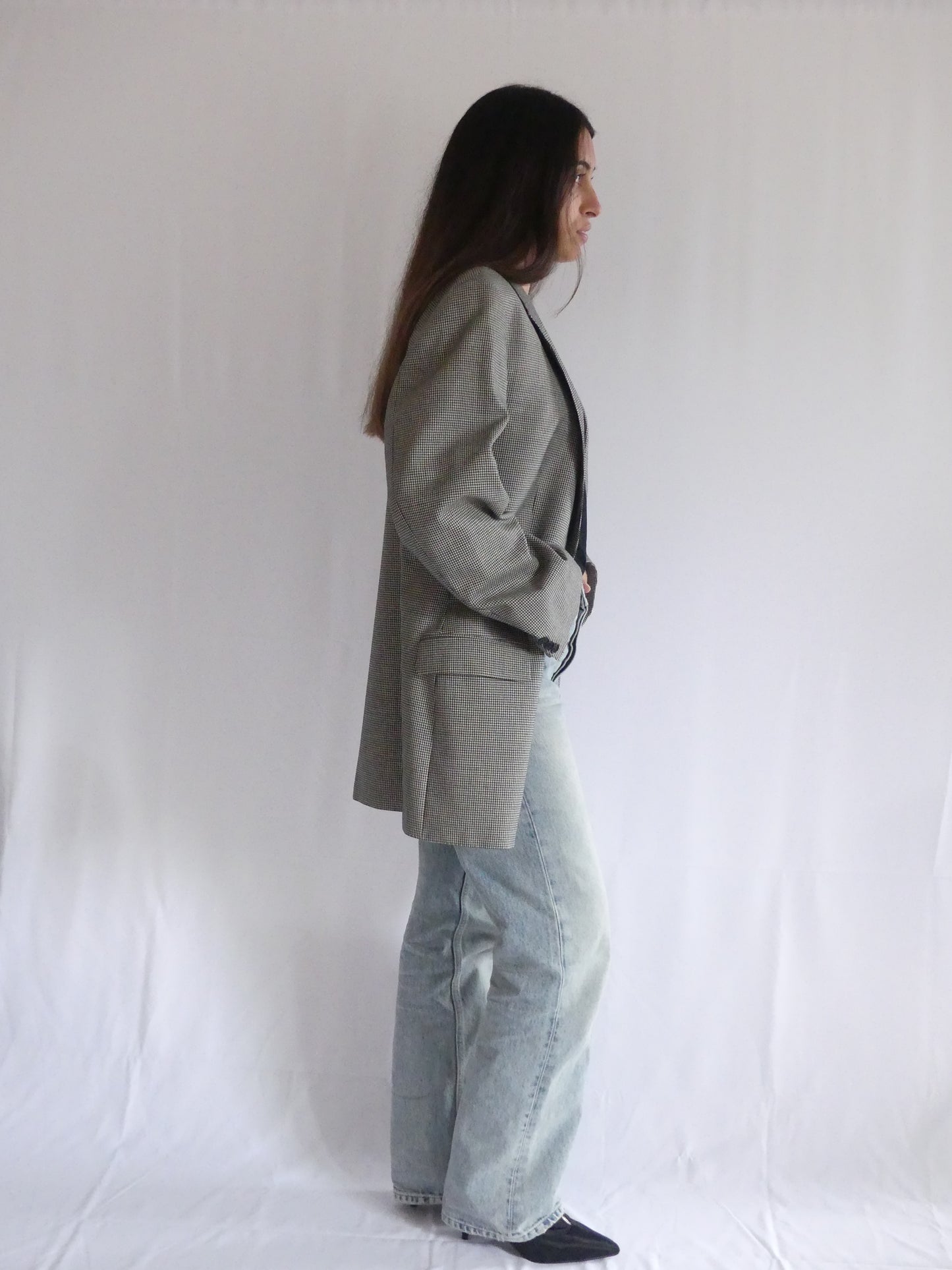 Woman wearing the Gaspard vintage blazer in black and white houndstooth, styled for a chic European look – made in France with luxurious English cloth.