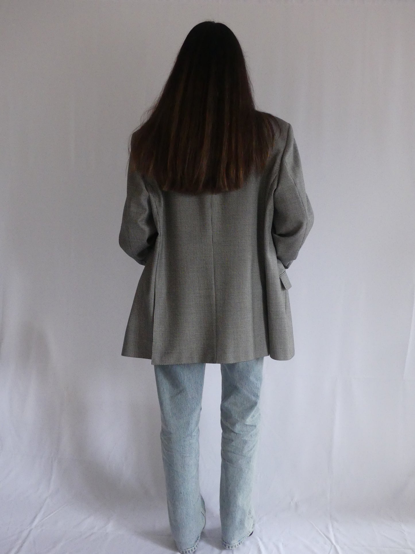 Woman wearing the Gaspard vintage blazer in black and white houndstooth, styled for a chic European look – made in France with luxurious English cloth.