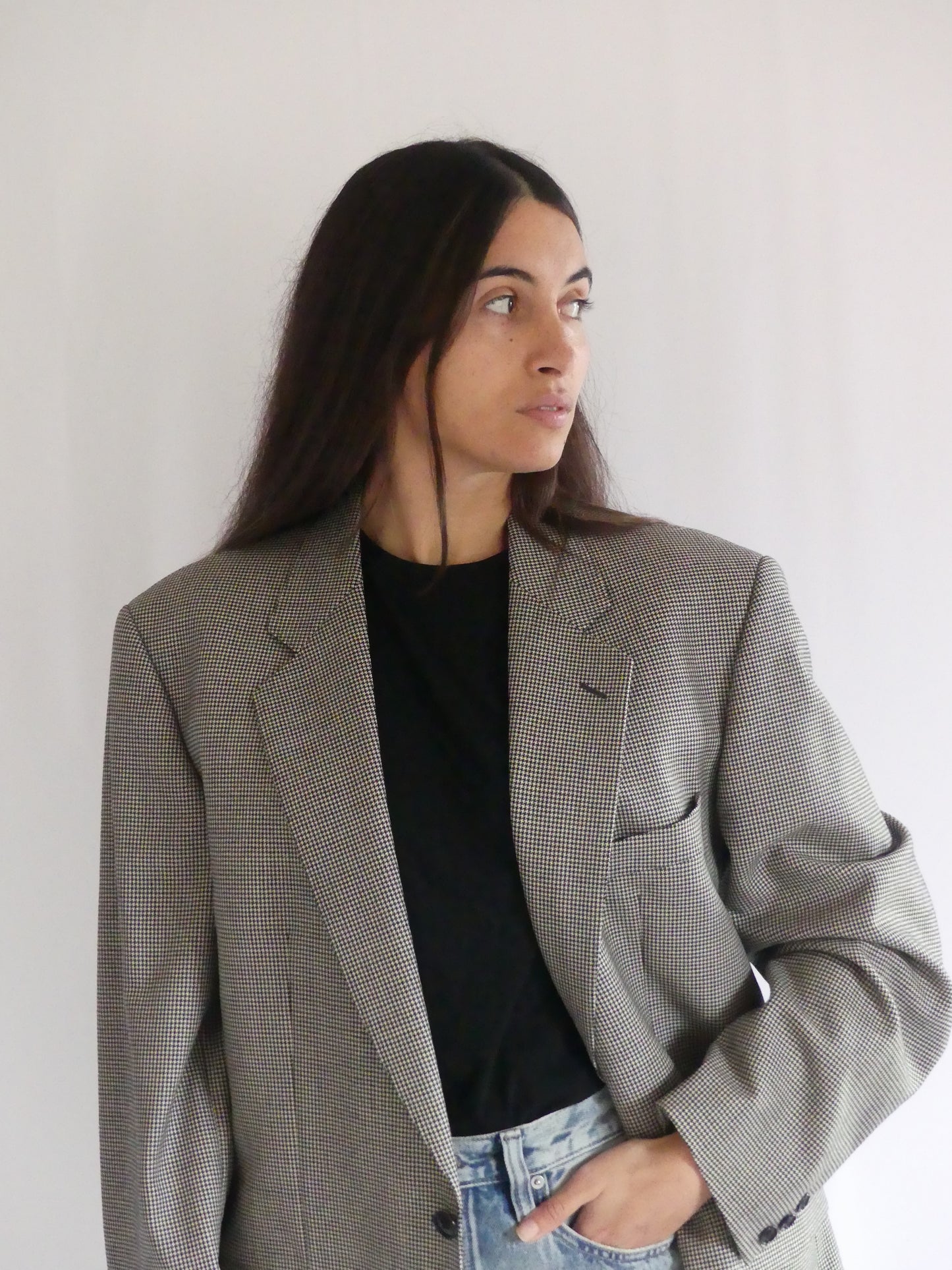 Woman wearing the Gaspard vintage blazer in black and white houndstooth, styled for a chic European look – made in France with luxurious English cloth.