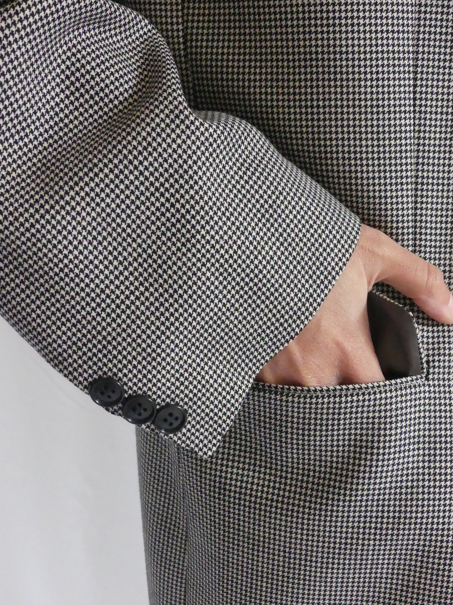 Close-up of black and white houndstooth fabric and buttons on the Gaspard vintage blazer, made from premium English cloth by Scabal London.