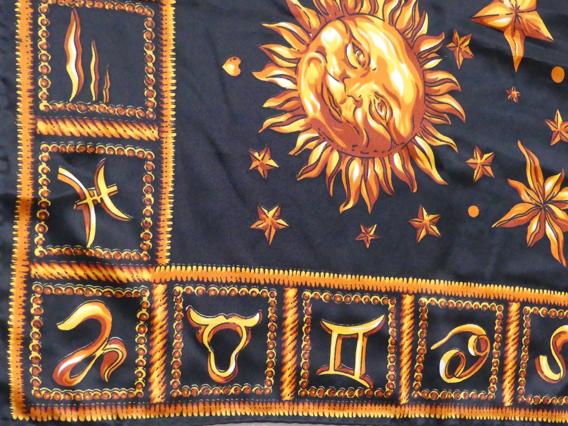 Elegant astrology silk scarf in black with golden celestial suns, stars, and planets, made in Paris from 100% silk – a luxurious holiday accessory or gift